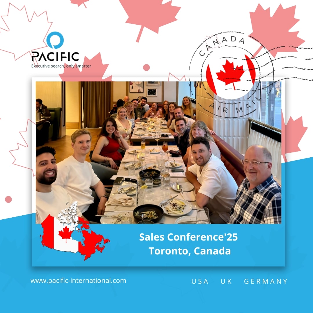 Eine Gruppe von Menschen sitzt bei einer Verkaufskonferenz in Toronto, Kanada, um einen Restauranttisch herum, während eine Kanada-Karte und eine Ahornblatt-Grafik das Bild überlagern - eine Einladung an Sie, sich unserem dynamischen Team anzuschließen.