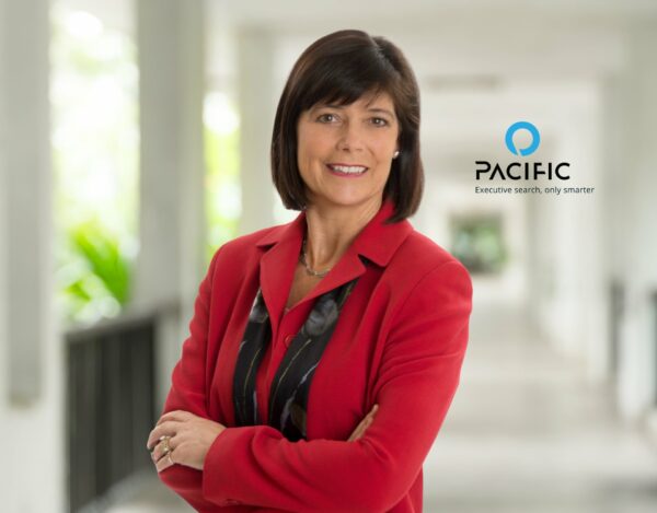 A woman in a red blazer stands with arms crossed in a corridor. The Pacific logo and slogan, "Executive search, only smarter," appear on the right.