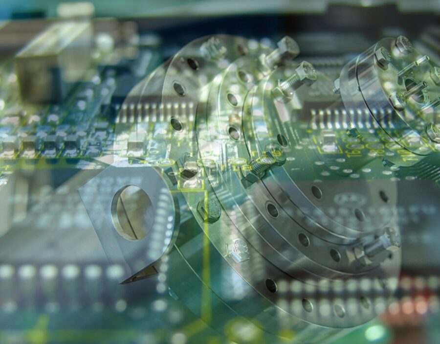 Close-up image showing a transparent overlay of electronic circuit boards and mechanical metal components, highlighting technology and engineering elements.