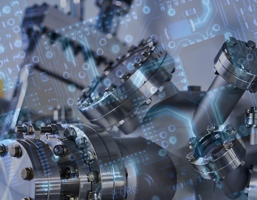 Industrial metal machinery overlaid with translucent circuit board patterns, symbolising the integration of technology and engineering.